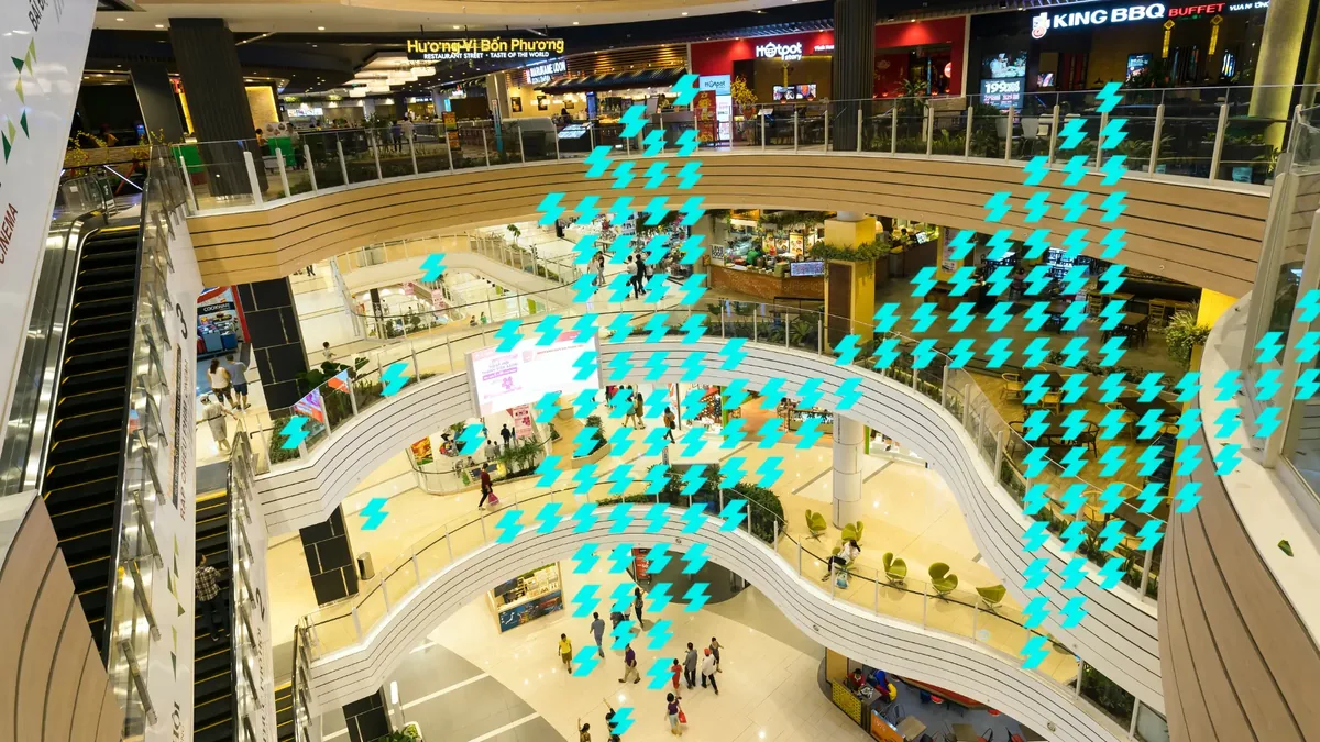 Vista interna de um shopping, com lojas e praça de alimentação
