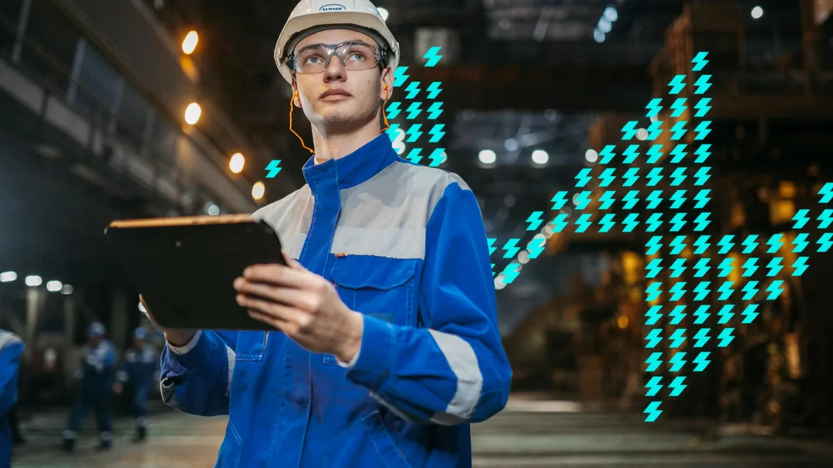Operador com capacete e tablet dentro de uma planta industrial